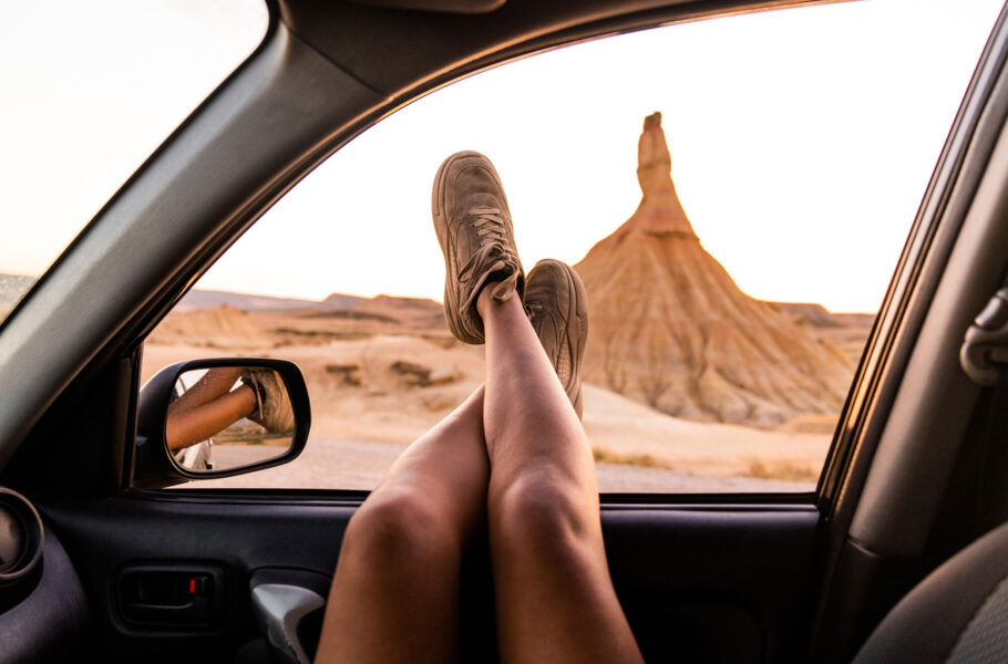 crossed legs of a woman out of the car window