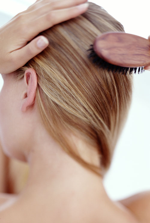 woman brushing hair, close-up,