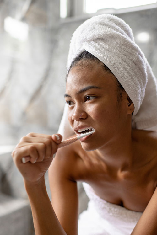 close up woman brushing teeth