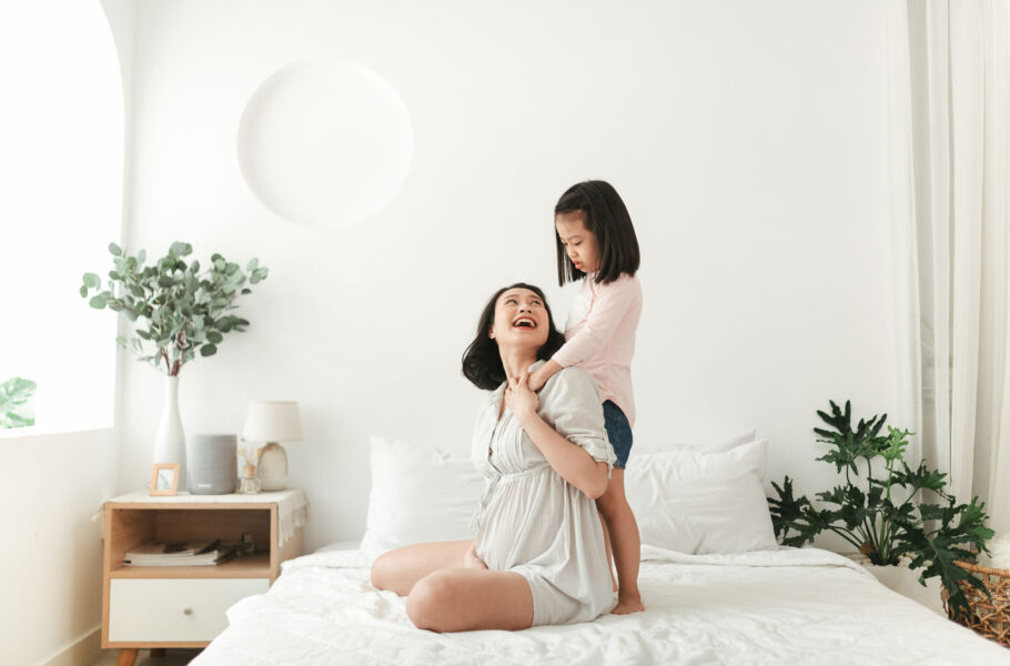 mother daughter hugging and laughing in bed
