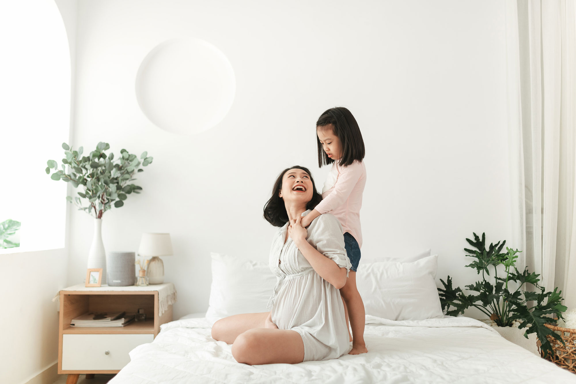 mother daughter hugging and laughing in bed