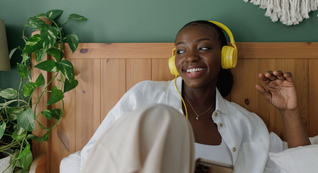 woman wearing headphones in bed