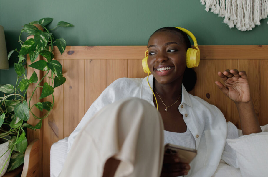 woman wearing headphones in bed