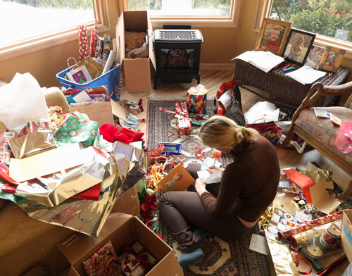 Woman sitting in living room writing on Christmas cards