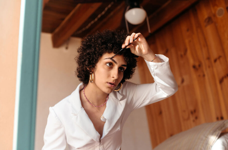 woman brushing eyebrows up at home