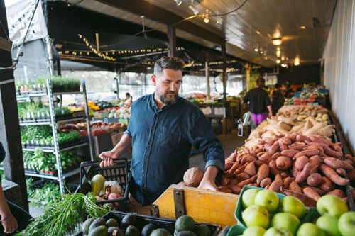 man choosing fruits and vegetables at the local grocery store