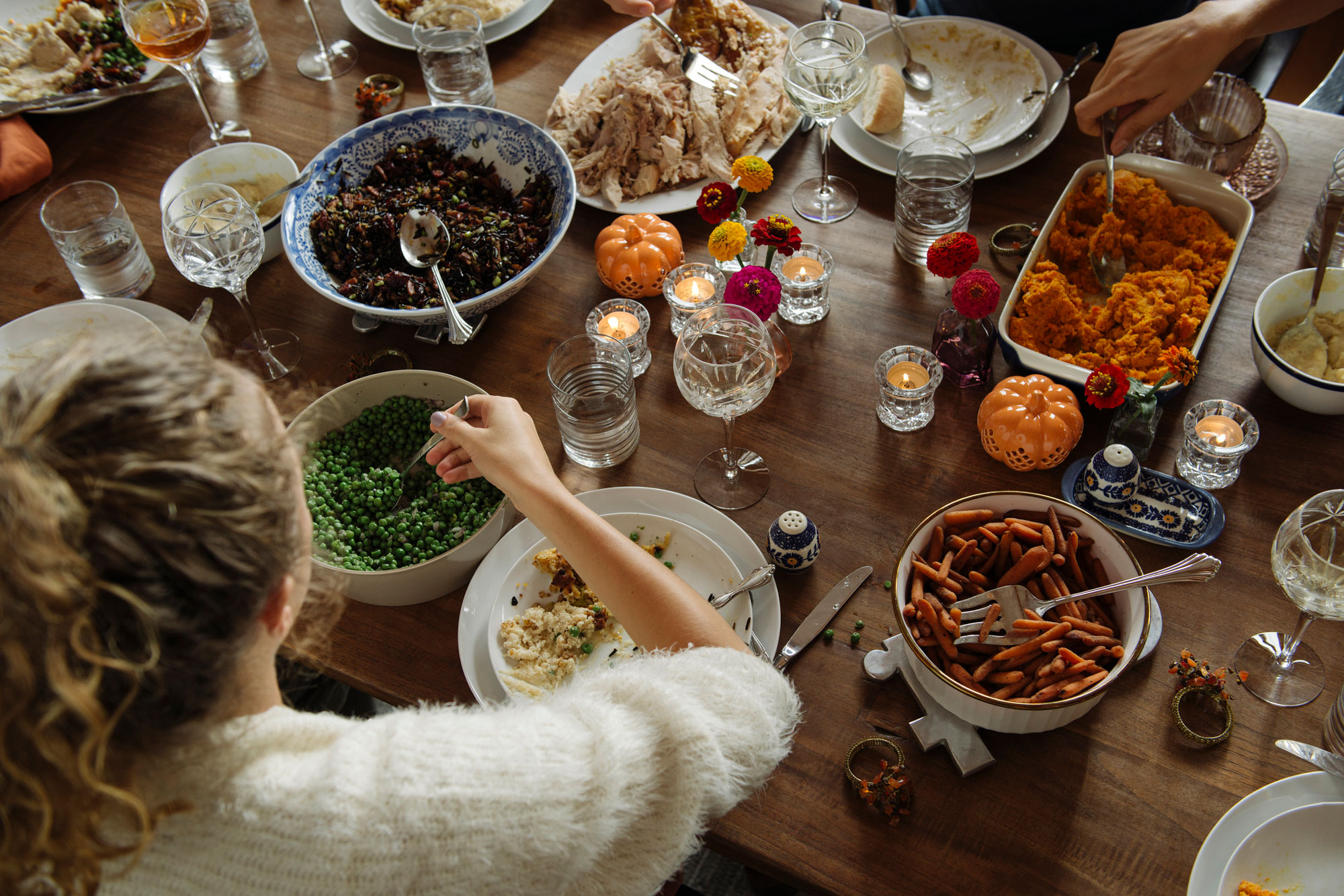 woman having food while sitting at dining table during Thanksgiving