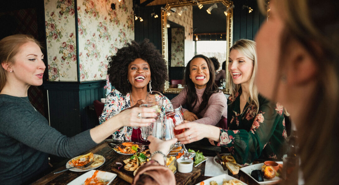 group of friends on dining table toasting