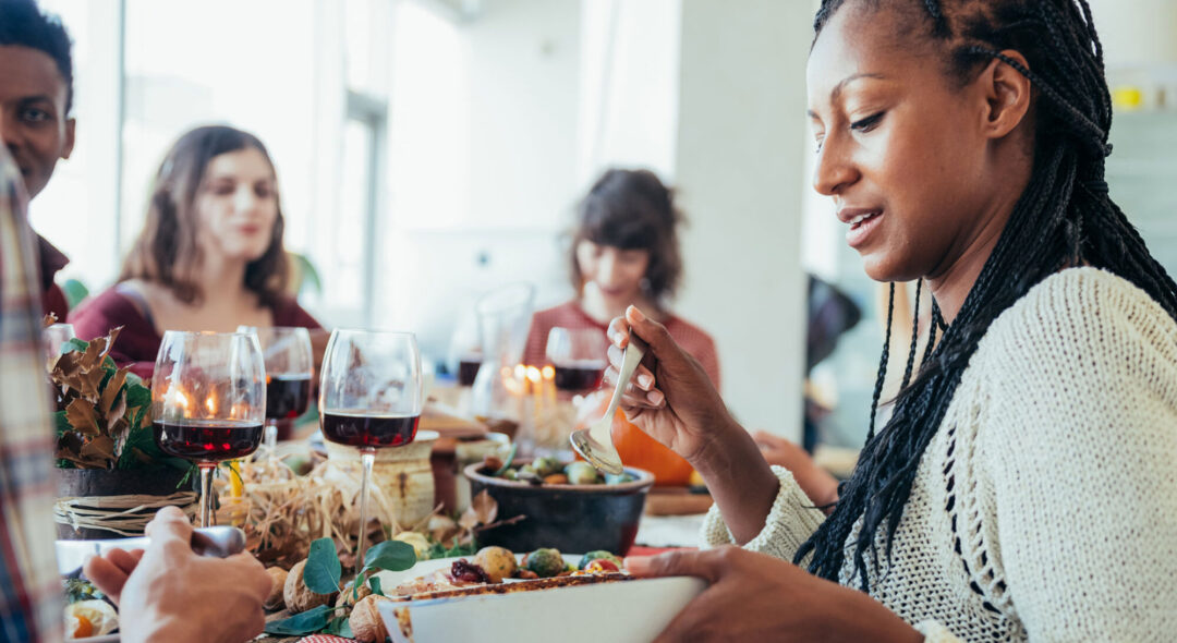 woman passing dish at dining table
