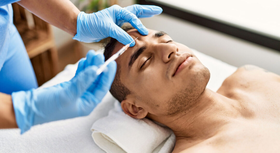 Doctor injecting botox on man face for anti aging treatment at the clinic