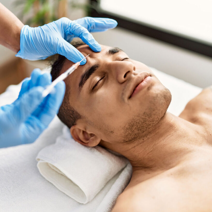 Doctor injecting botox on man face for anti aging treatment at the clinic