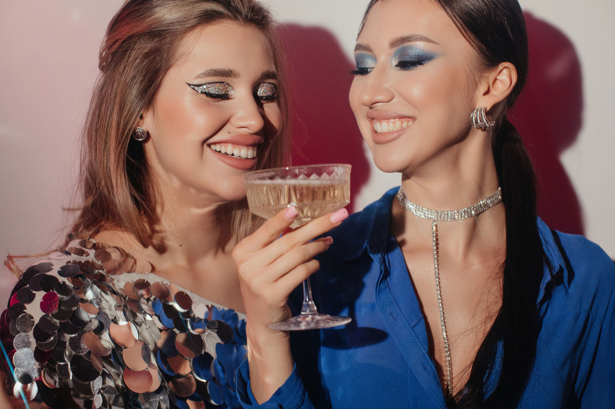 Two girlfriends with champagne at party