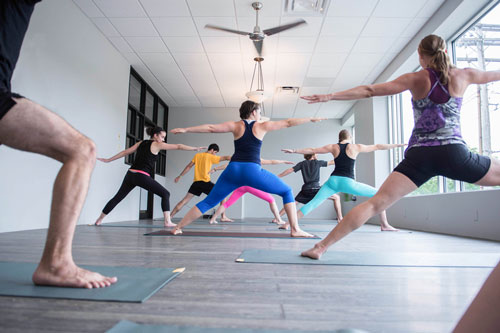Students in a yoga class are in warrior pose