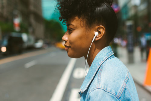 Young woman walking with headphones in city