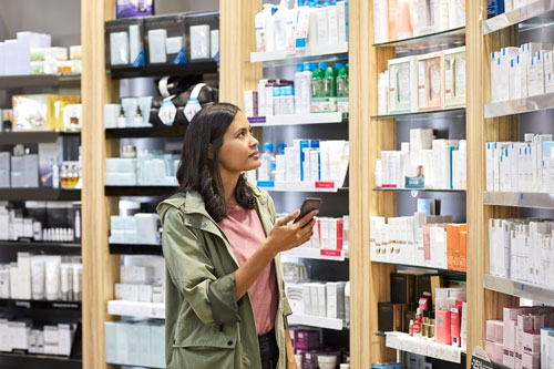 customer searching medicine on shelf from rack at pharmacy