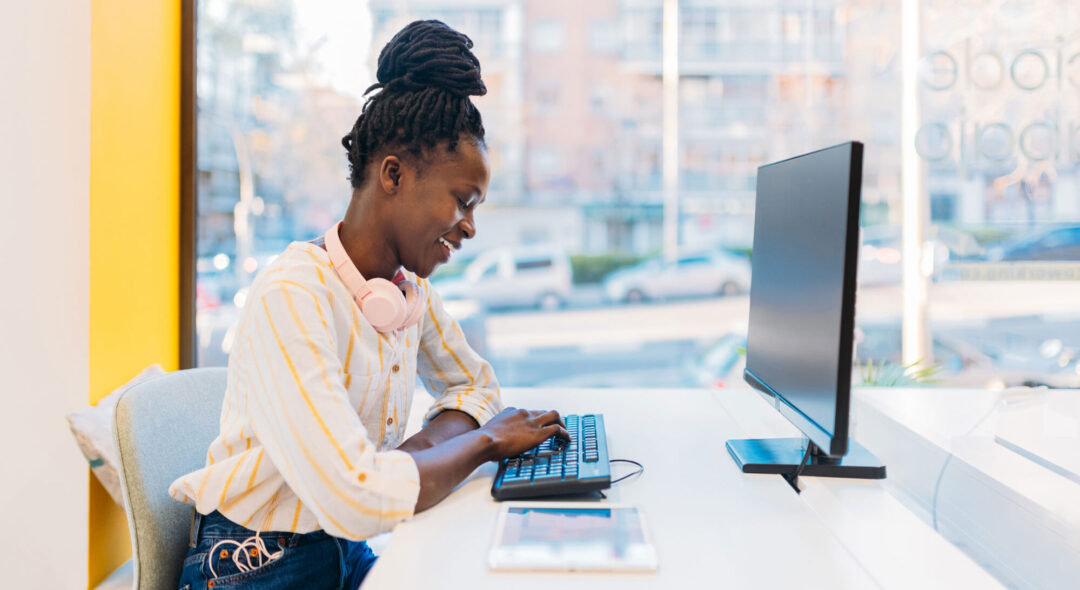 woman typing on keyboard and watching screen