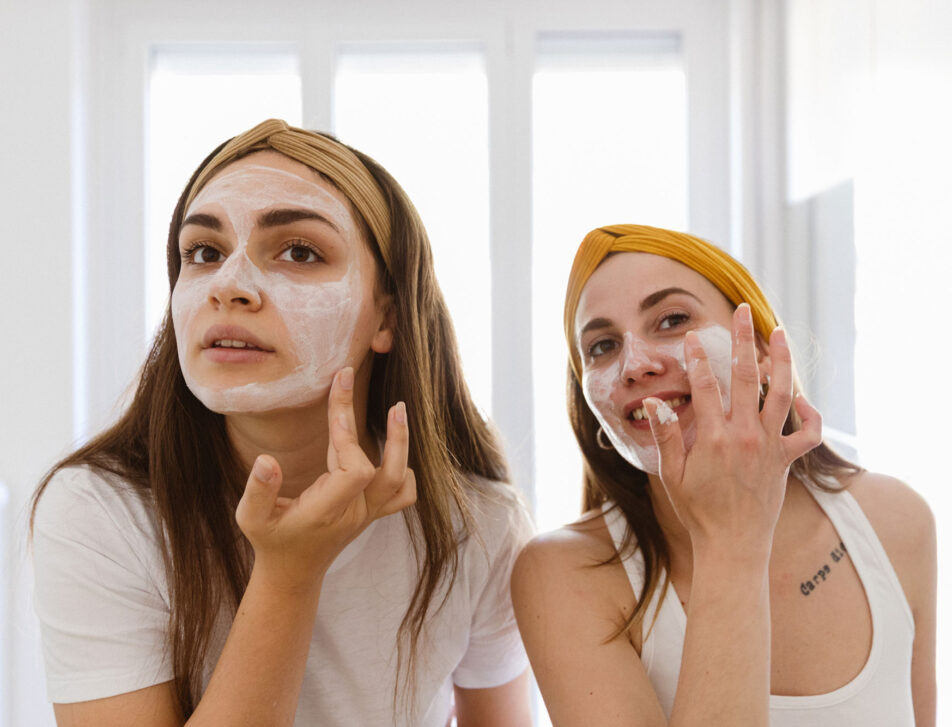 woman applying clay mask on face at home