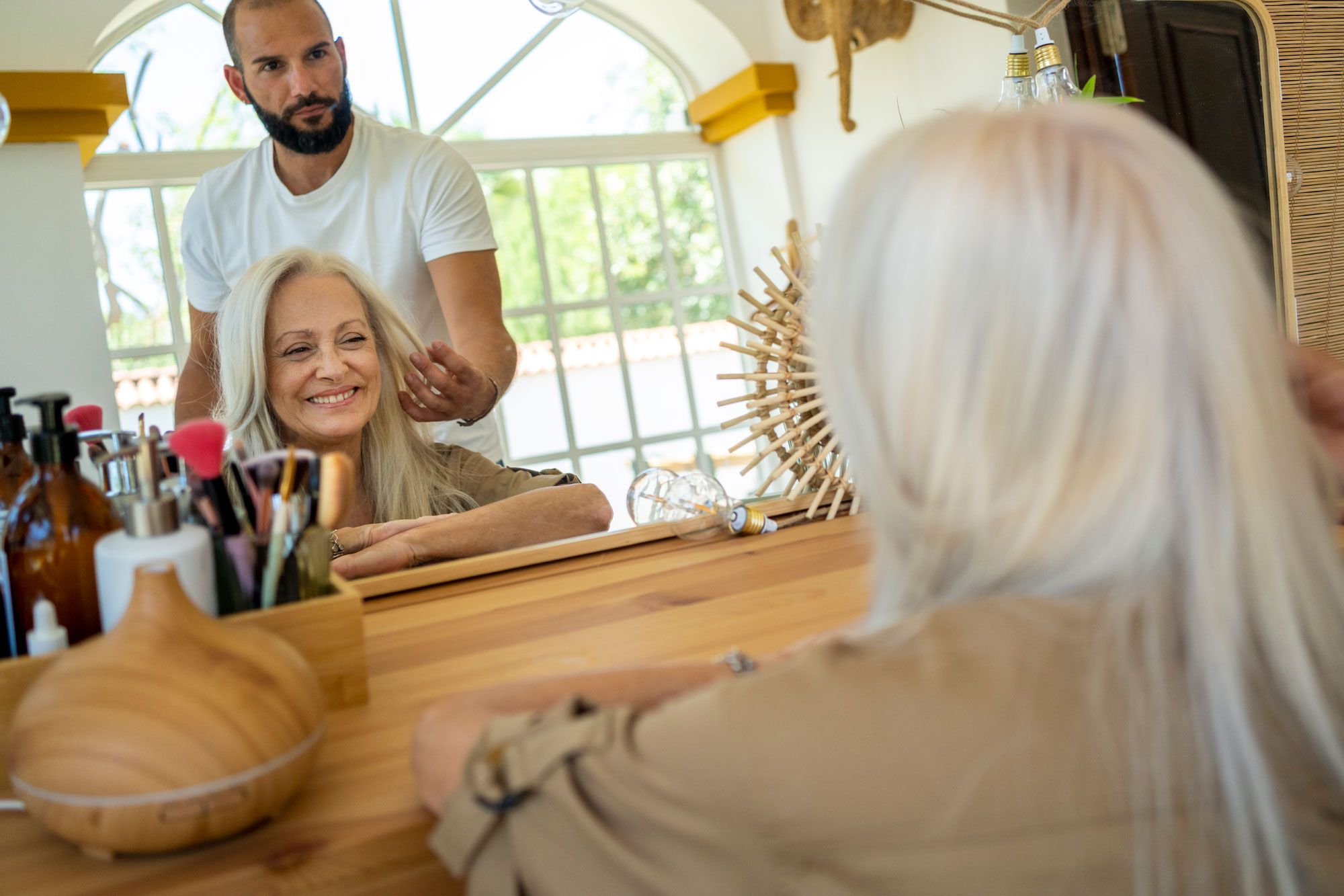 Woman looking at her hairstyle at mirror