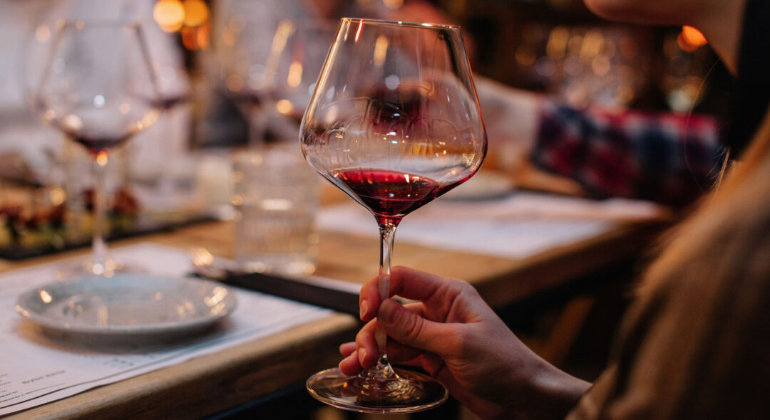 Closeup shot of unrecognizable female holding glass of red wine