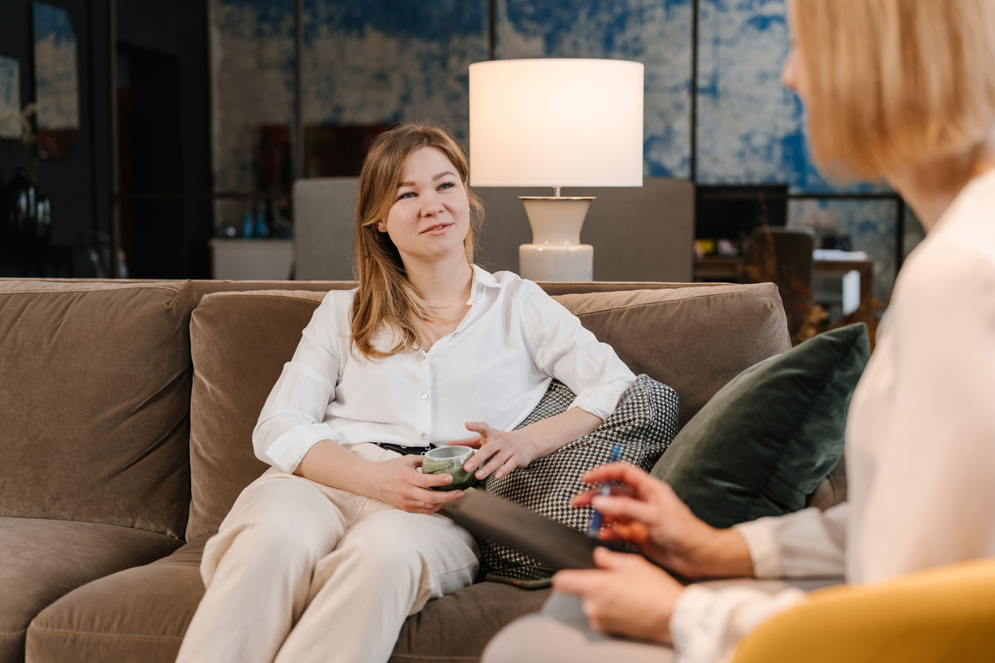 Woman sitting on sofa during psychotherapy session with psychologist