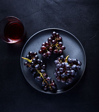 Bunches of concord Grapes with a Glass of Grape Juice
