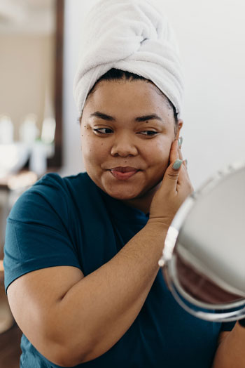 Smiling woman doing skin care treatment at home