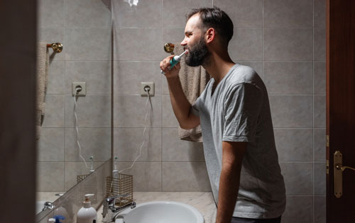 Man brushing teeth in bathroom
