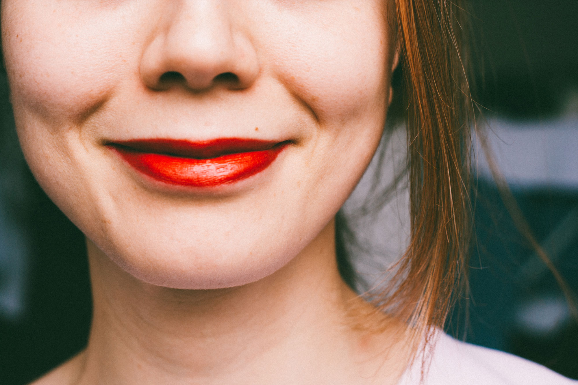 Part of a woman's face wearing red lipstick