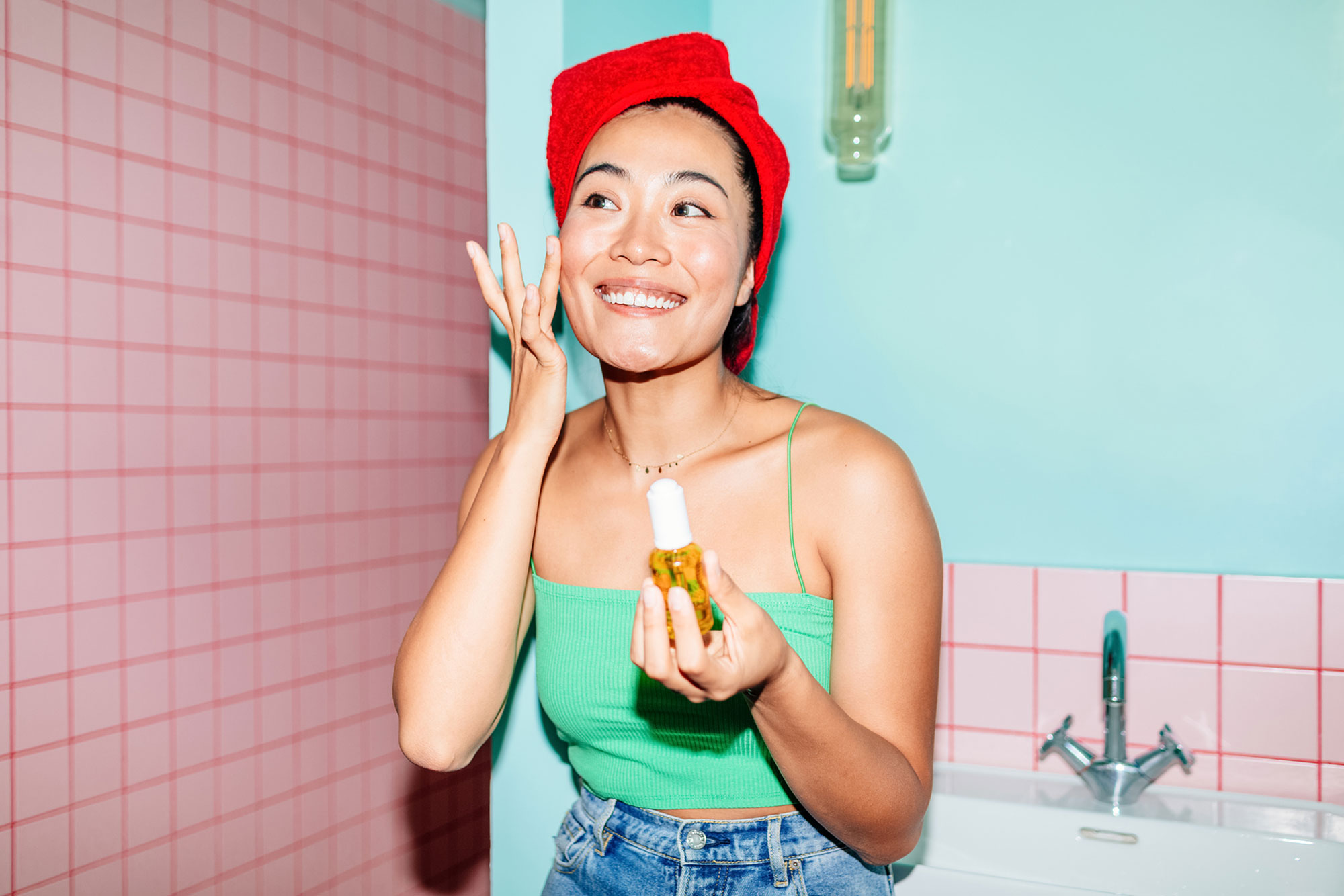 woman applying skincare products in bathroom