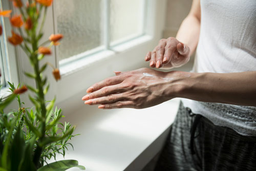 woman applying cream on her hand